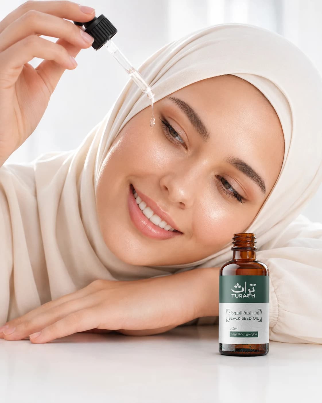 Femme tenant une bouteille d'huile Turath